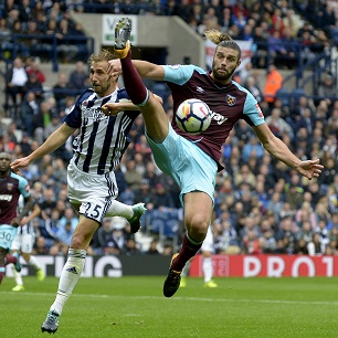 Andy Carroll challenges Craig Dawson for possession