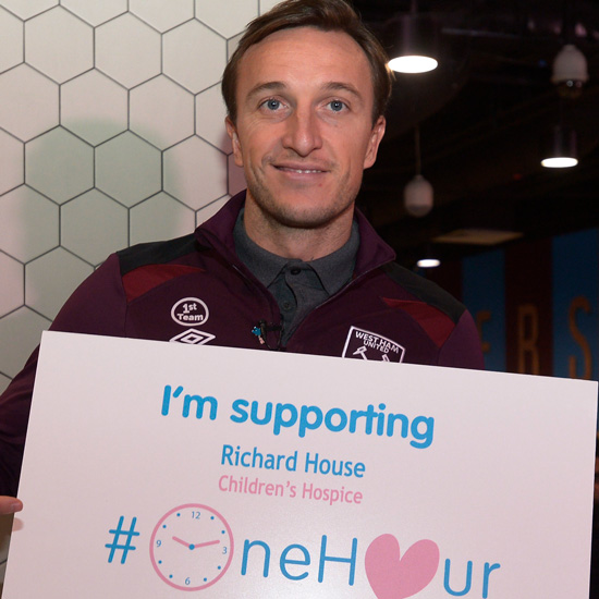 Mark Noble with a card supporting the Richard House #OneHour campaign