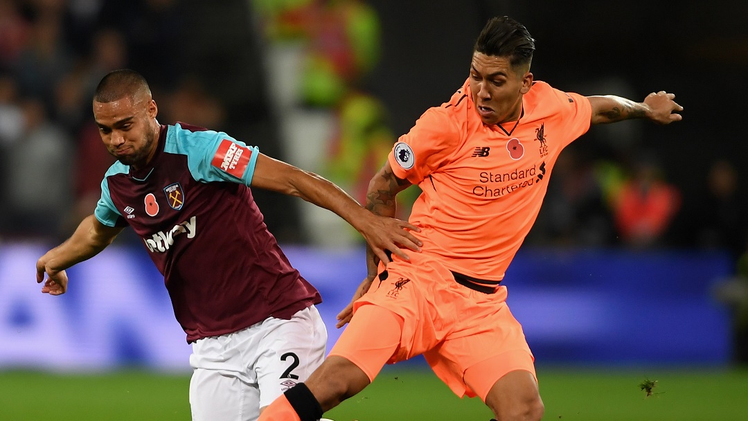 Winston Reid battles for possession with Roberto Firmino