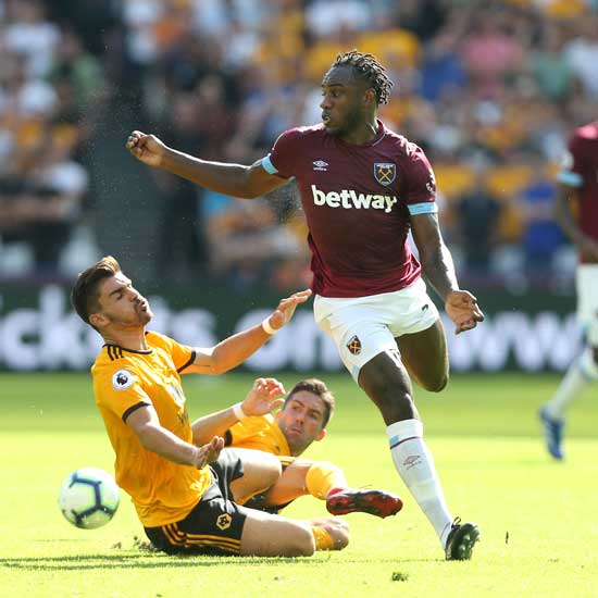 Michail Antonio is challenged by Ruben Neves
