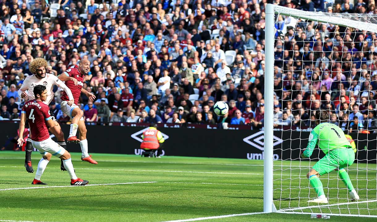 Lukasz Fabianski prepares to make a save from Marouane Fellaini