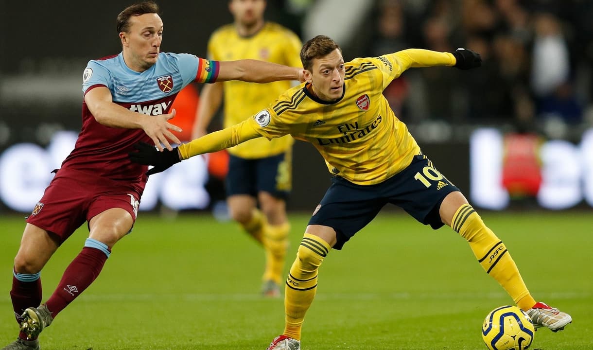 Mark Noble grapples with Mesut Ozil