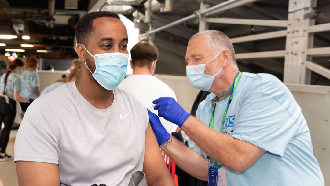 A man having a COVID-19 vaccination at London Stadium