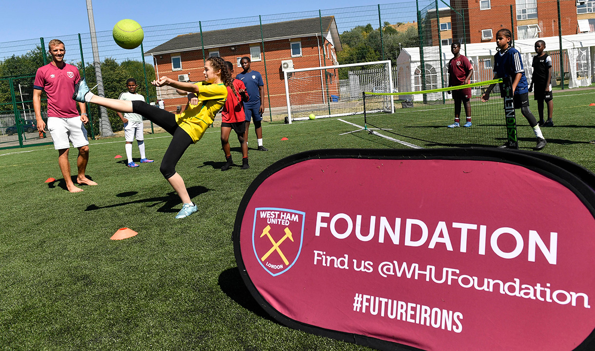 Soucek watches on as kids play football at the Foundation