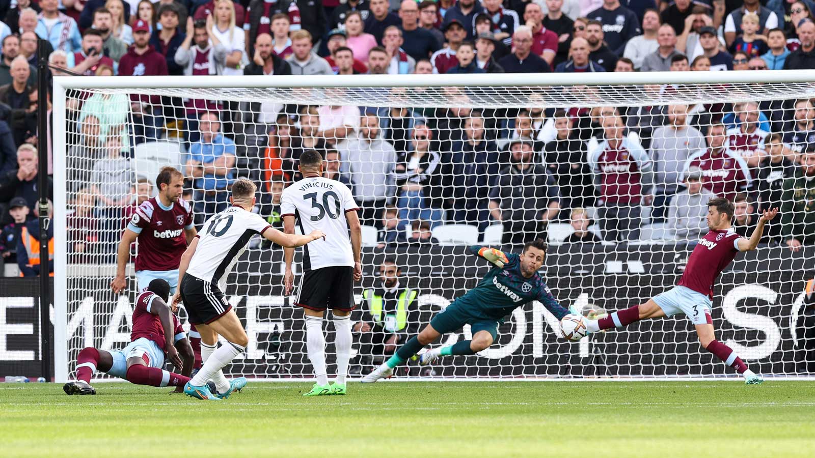 Aaron Cresswell blocks from Fulham's Tom Cairney