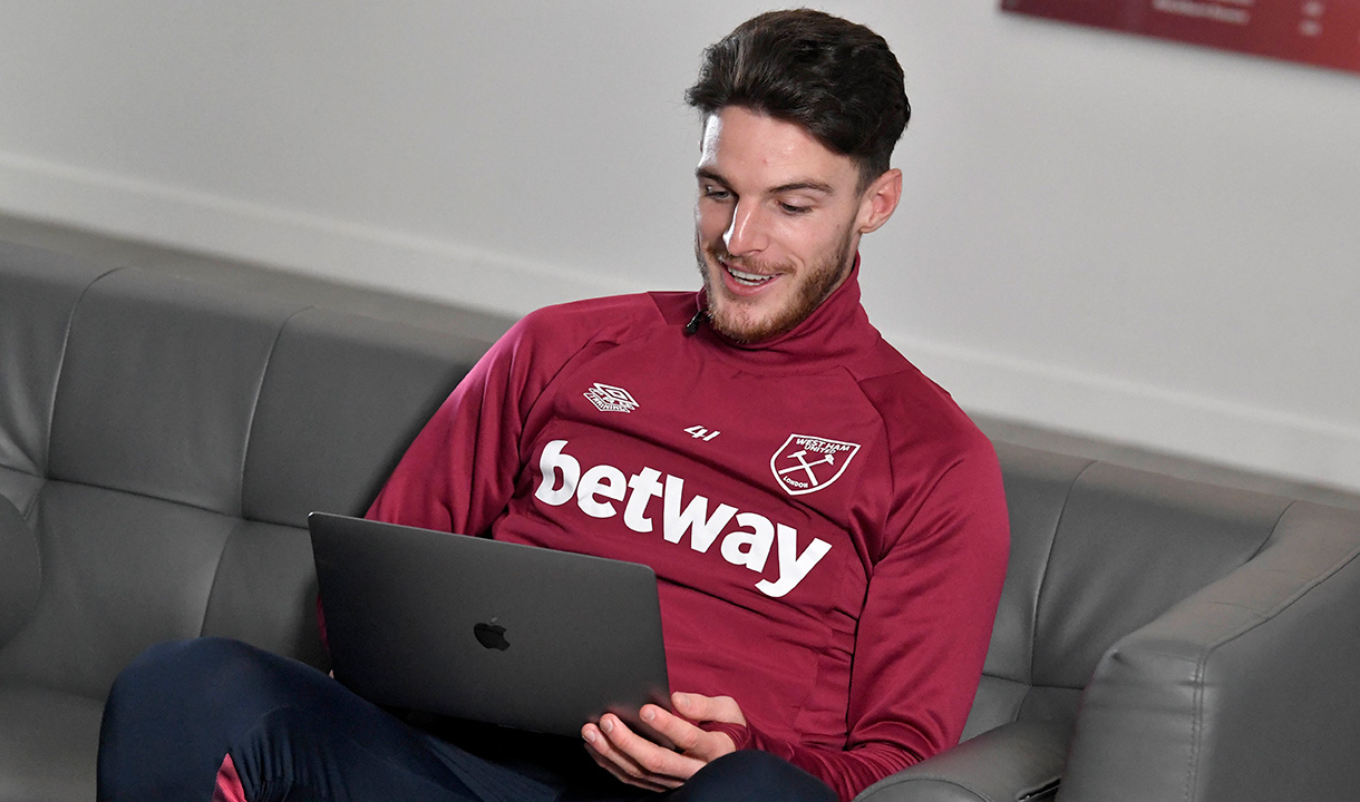 Declan Rice looks at a laptop screen