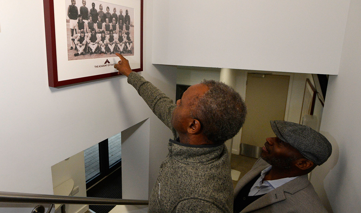 Ade Coker points at a picture of himself at Chadwell Heath