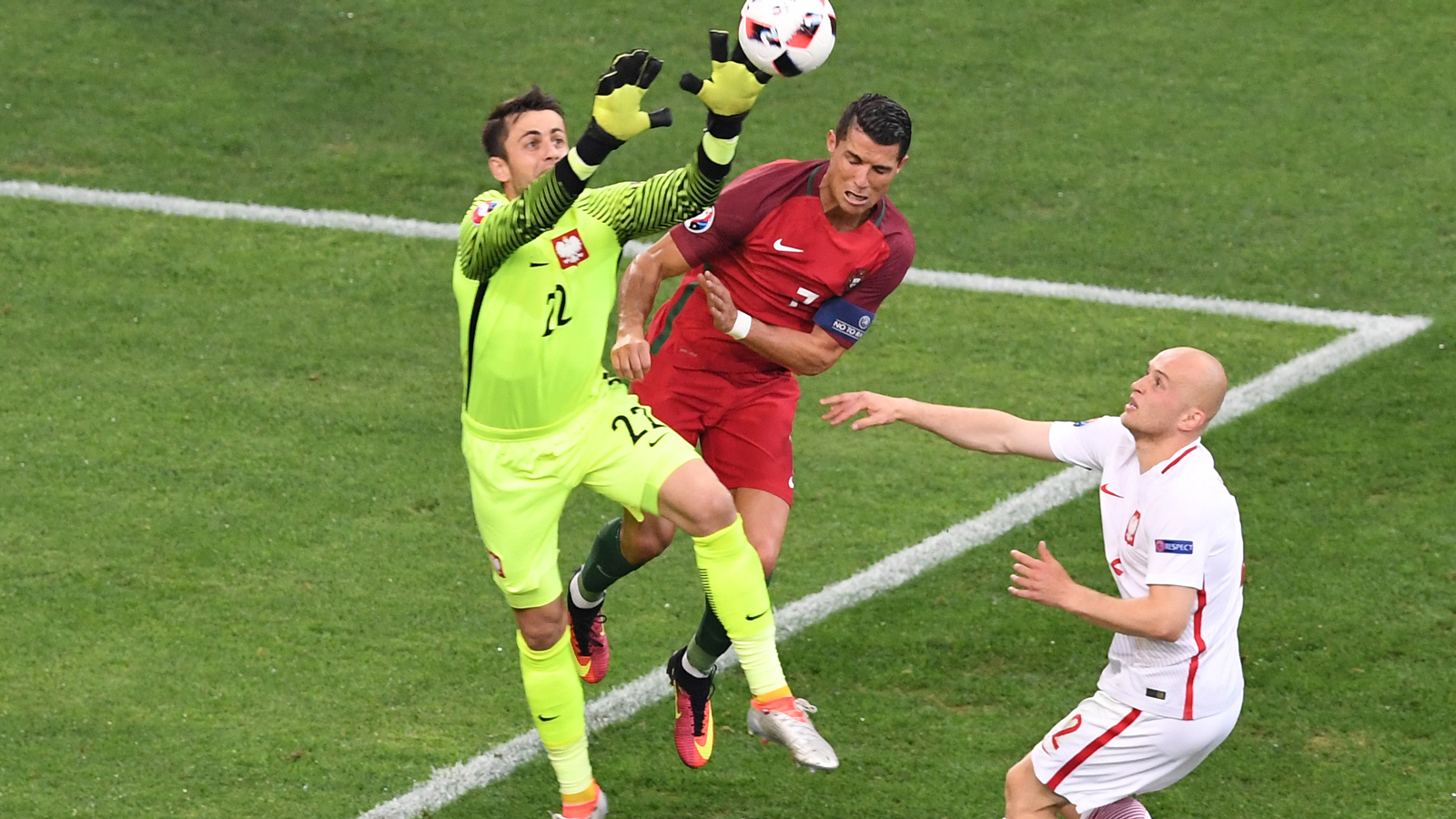 Łukasz Fabiański claims the ball under pressure from Cristiano Ronaldo