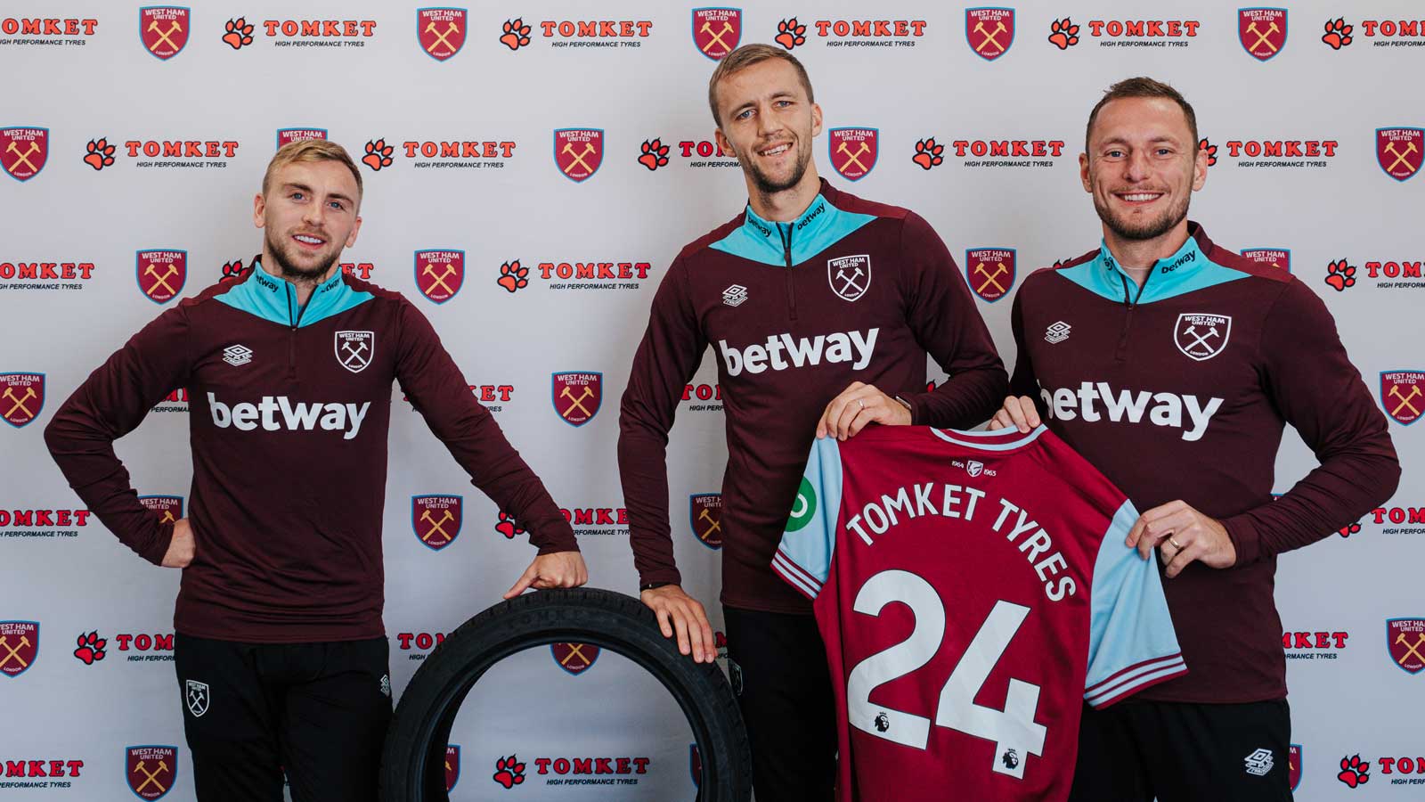 Jarrod Bowen, Tomáš Souček and Vladimír Coufal pose with a Tomket Tyres tyre and a West Ham United shirt with Tomket Tyres 24 printed on its back