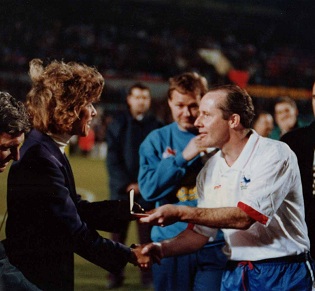 Stephanie Moore presents a medal to Liam Brady