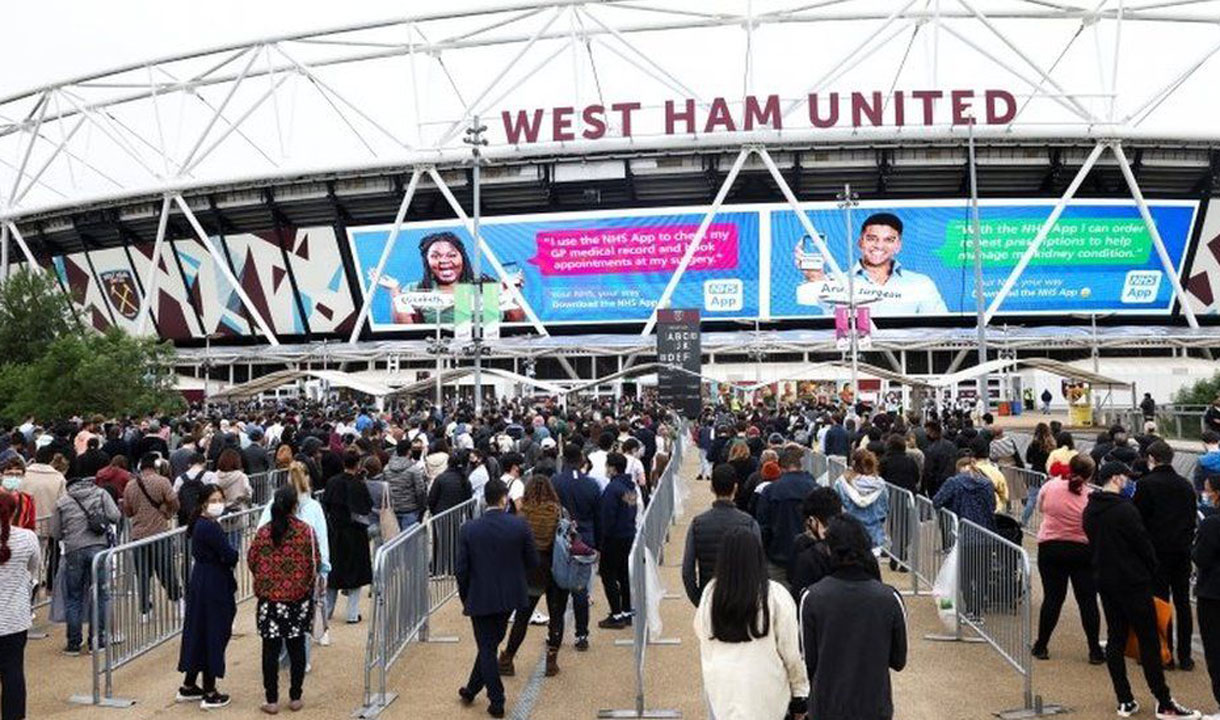 People queue for a COVID-19 vaccination at London Stadium