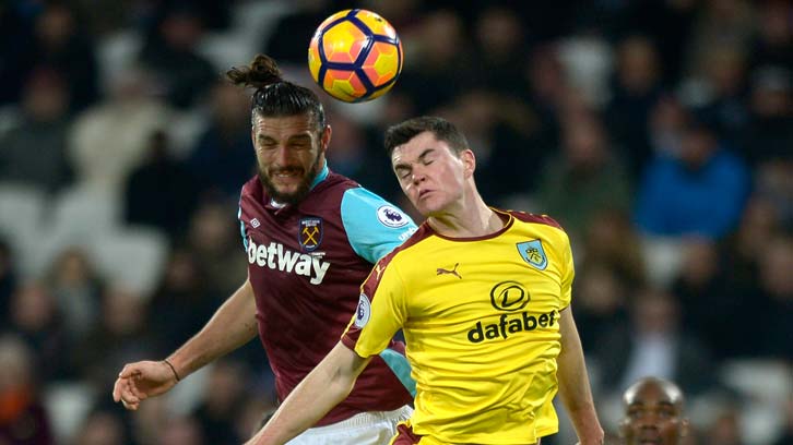 Andy Carroll jumps for a header with Michael Keane