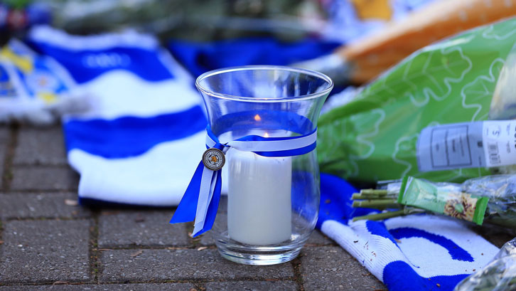 A candle of remembrance burns outside the King Power Stadium