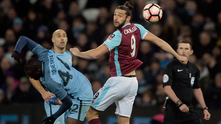 Andy Carroll jumps for a header against Manchester City