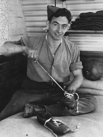 Harry Medhurst laces his football boots while at his Army barracks