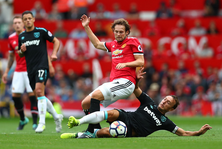 Mark Noble slides in to tackle Daley Blind