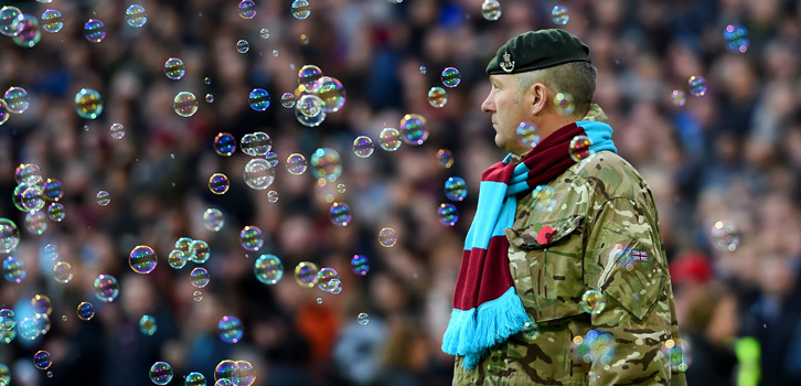 A soldier observes a minute's silence at the Boleyn Ground