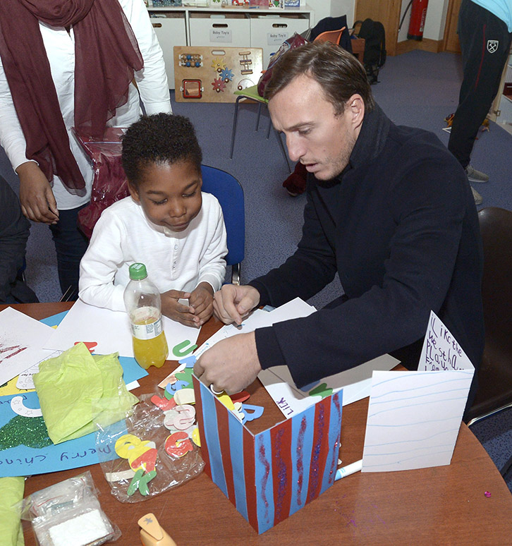 Mark Noble makes Christmas cards with a child at Richard House during the Club's Christmas Visit 2016