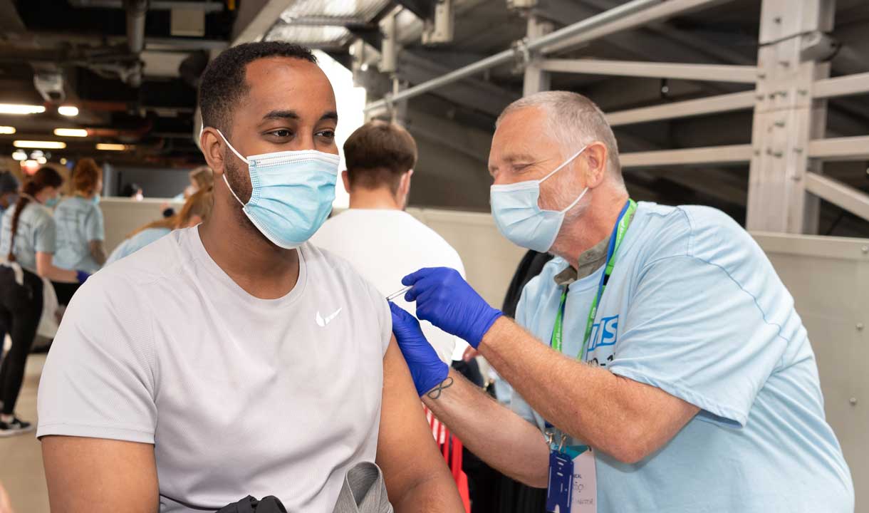 A man having a COVID-19 vaccination at London Stadium